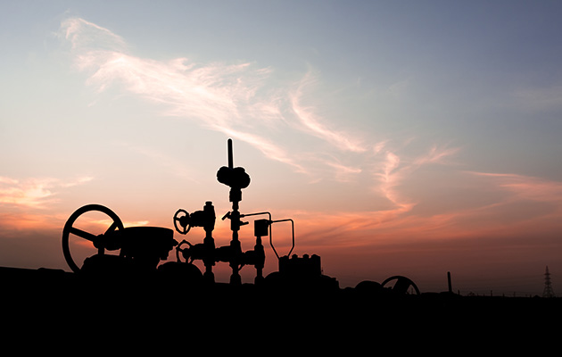 Silhouette of wellhead assembly on oil well in oilfield